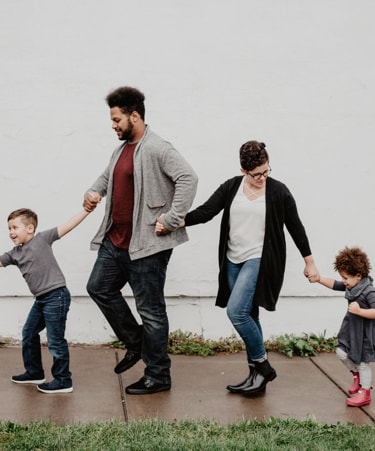 A familiy of four taking each other's hand